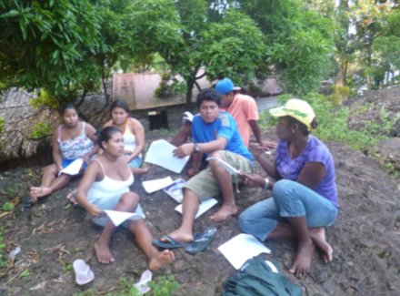 Foto del estudiante del técnico básico revisando encuestas en su trabajo comunitario de promotoria en temas de cambio climático